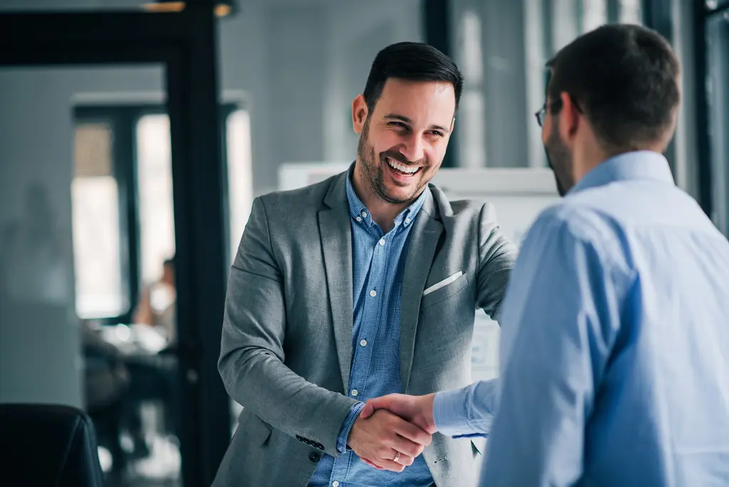 Two business owners sealing an agreement with a handshake: legal services for companies and entrepreneurs in Peru